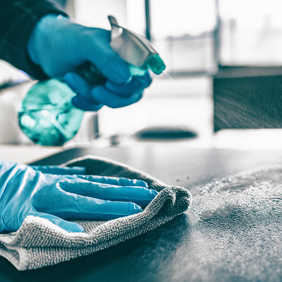 Worker Cleaning Table Surface in a Home